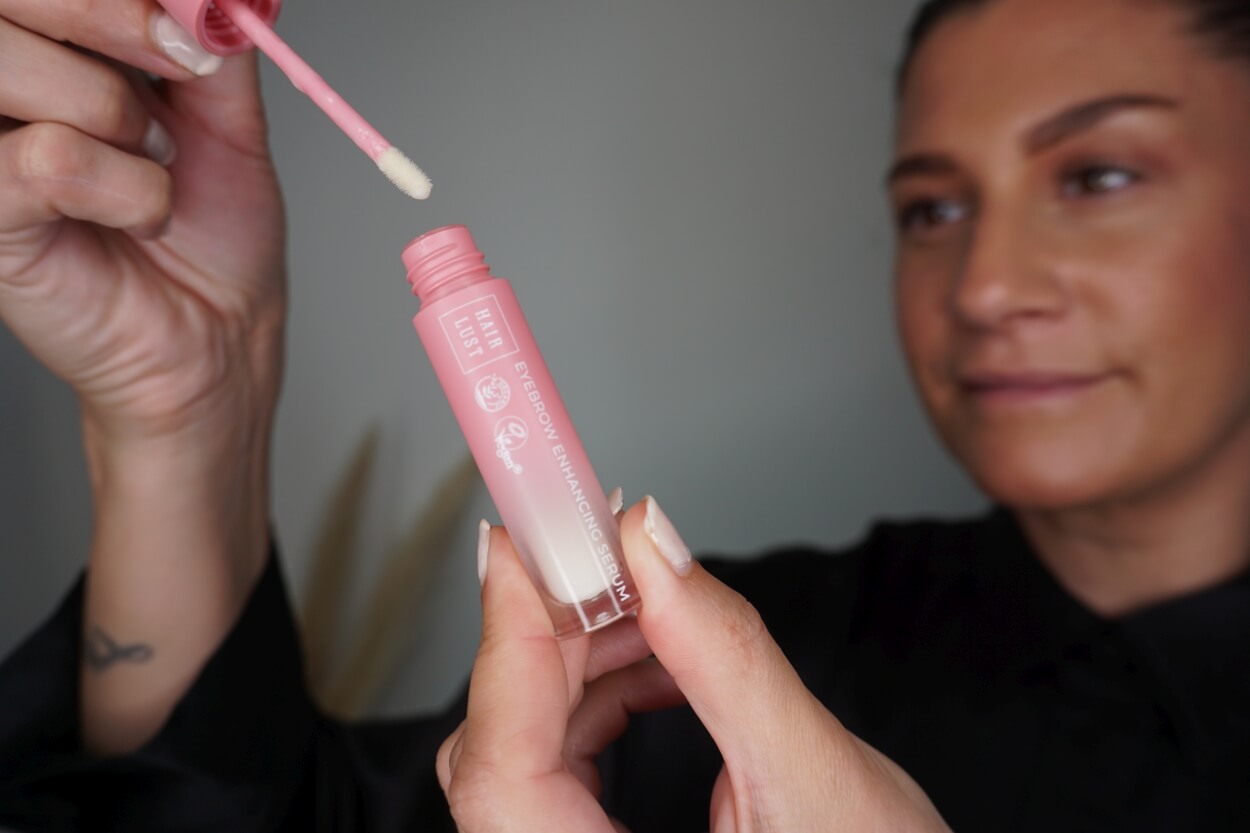 Kvinde tager Hairlust øjenbrynsserum ud af emballagen