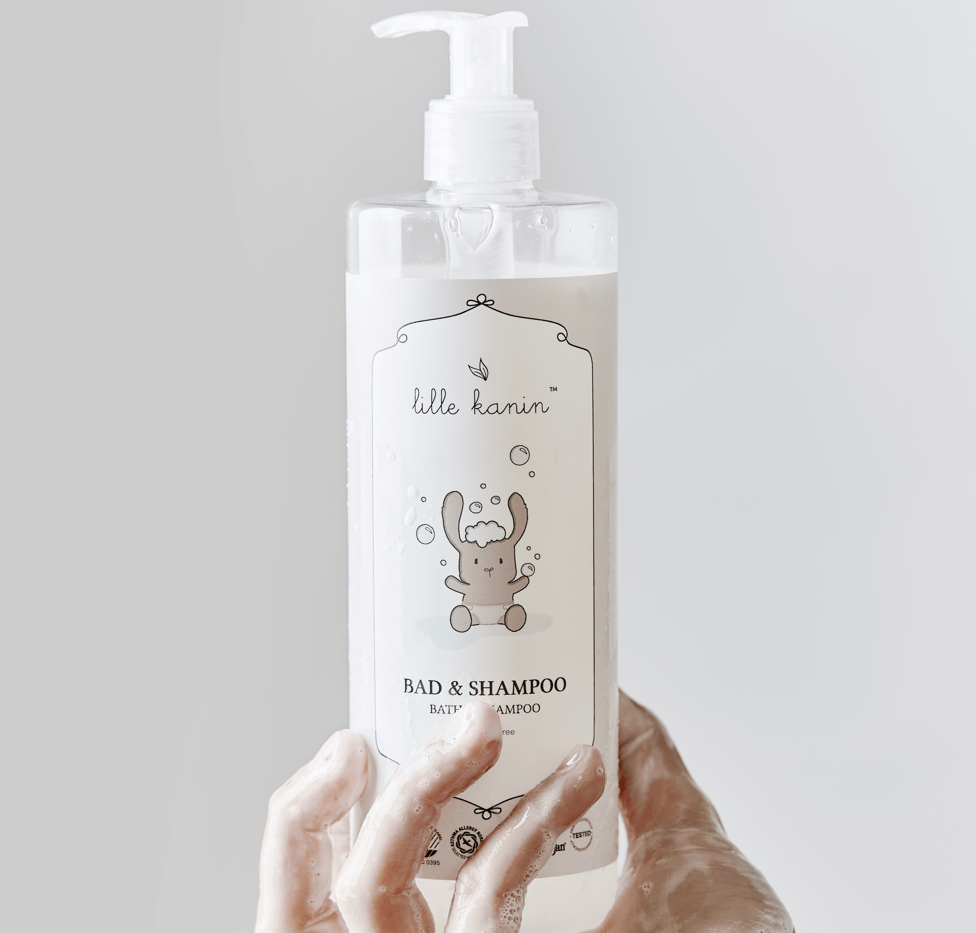 Lille Kanin Bad og shampoo i en hånd med hvid baggrund