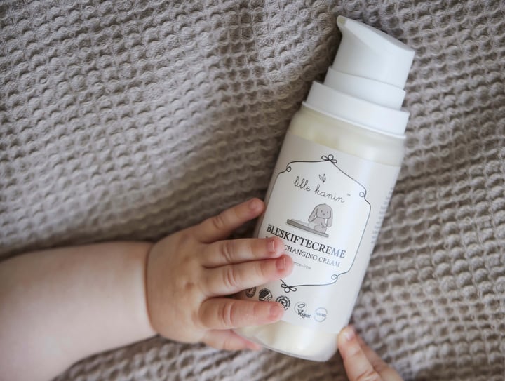 Lille kanin bleskiftecreme i hænderne på en baby