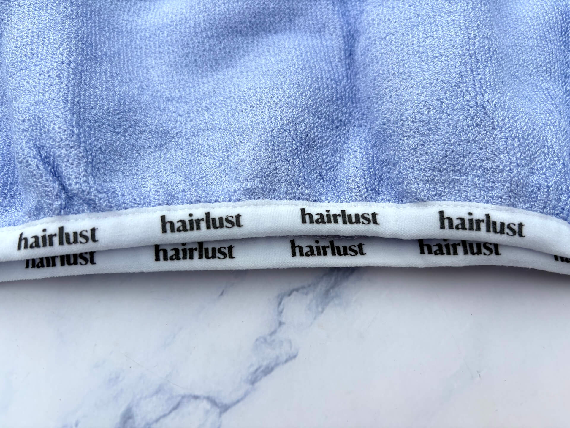 Logo på kant af Hairlust Bamboo Hair Towel Wrap hårhåndklæde