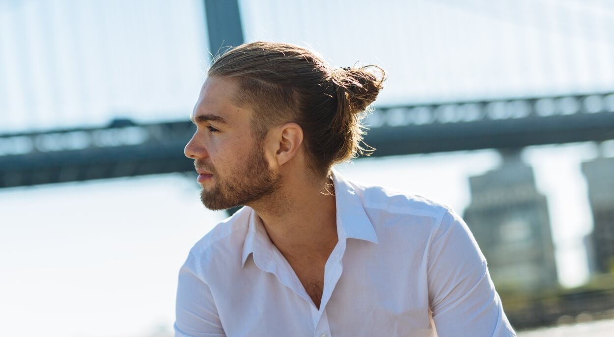 Mand med manbun og hårelastik i håret