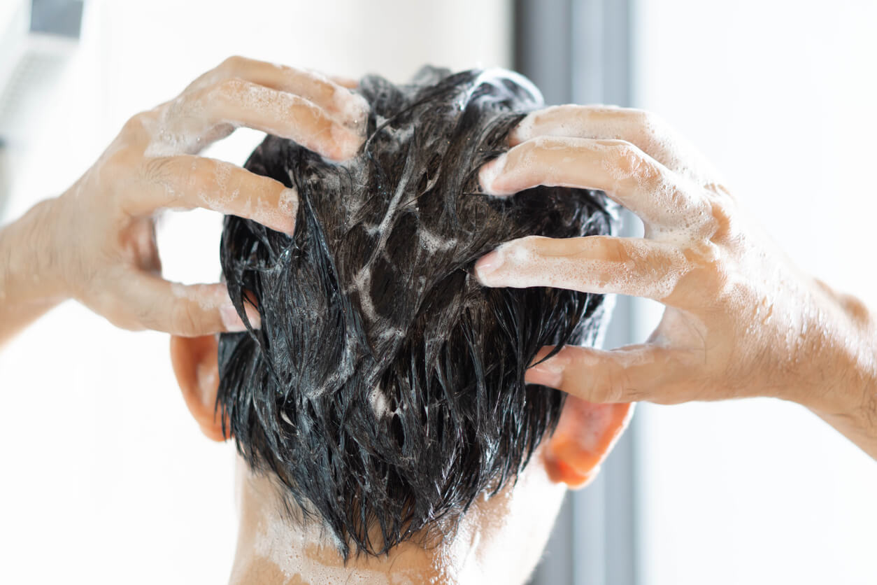 Mand vasker hår med shampoo mod hårtab og masserer hovedbunden