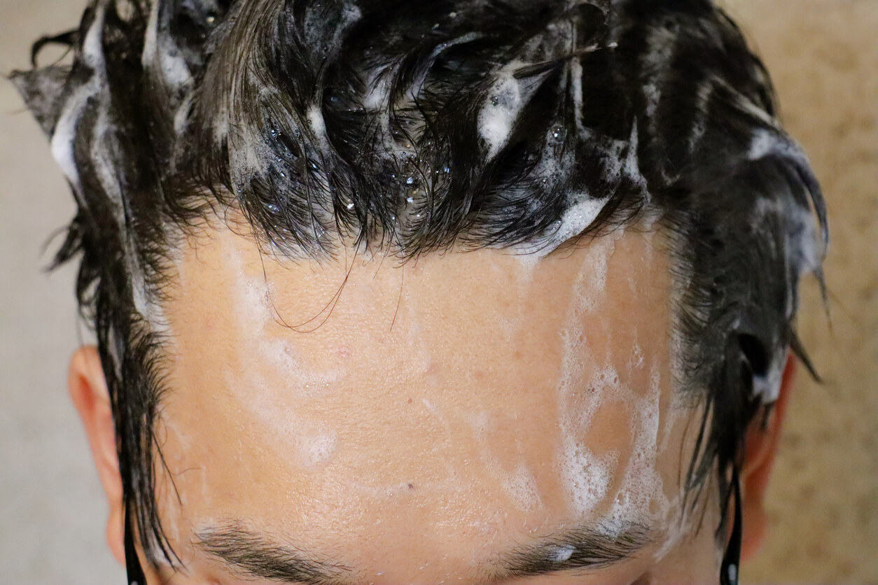 Mand vasker hår med skælshampoo til mænd