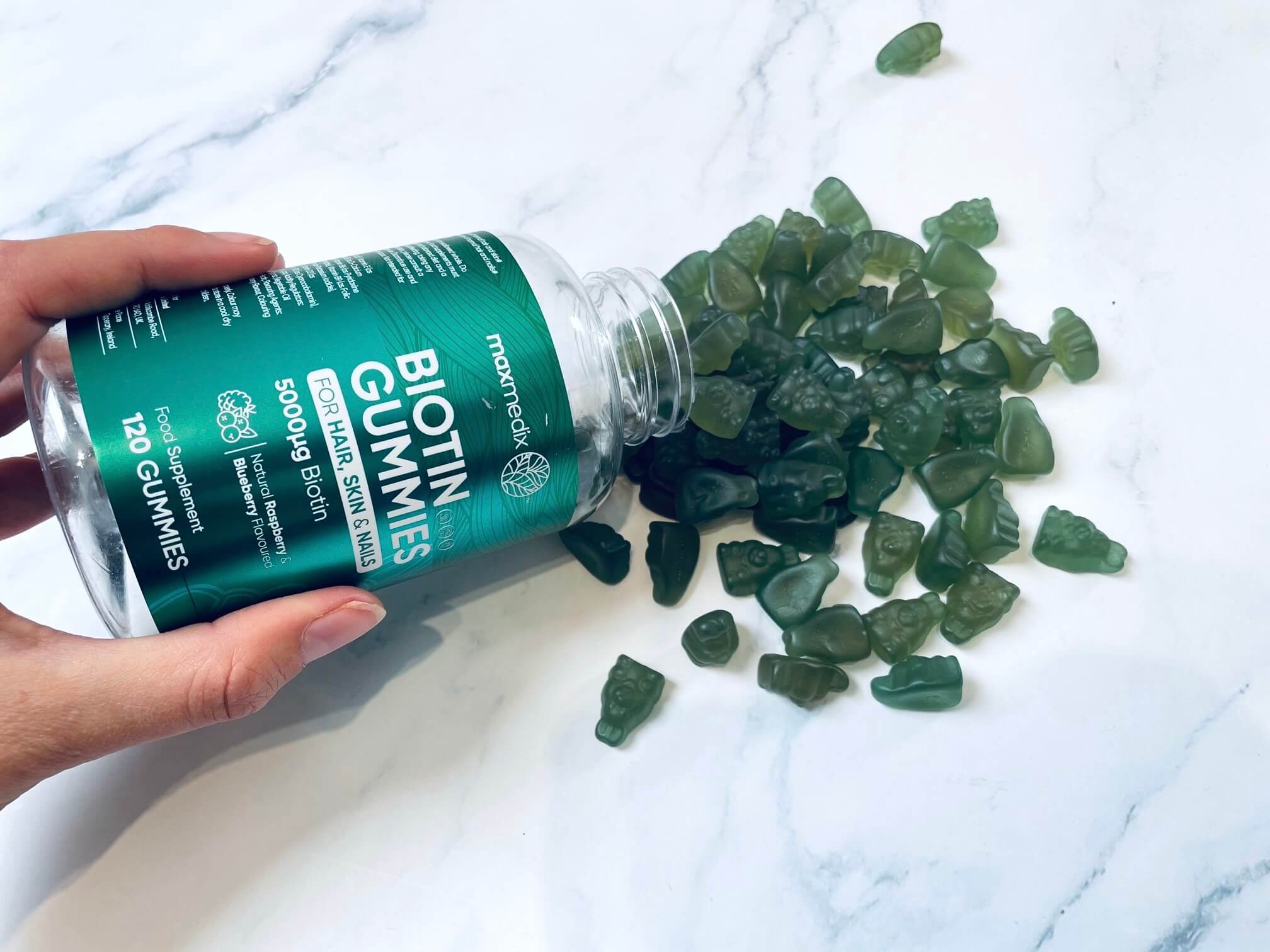Maxmedix Biotin Gummies der hældes ud på bord