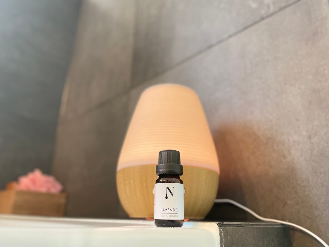 Naturligolie lavendelolie med en diffuser i baggrunden