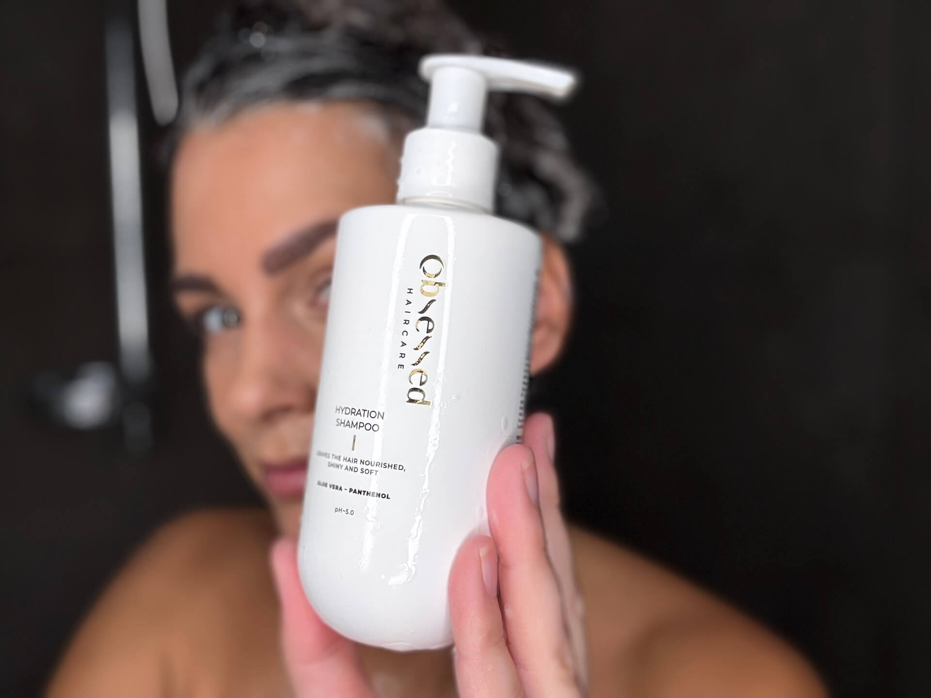 Obsessed Haircare Hydration Shampoo holdes af kvinde i bad