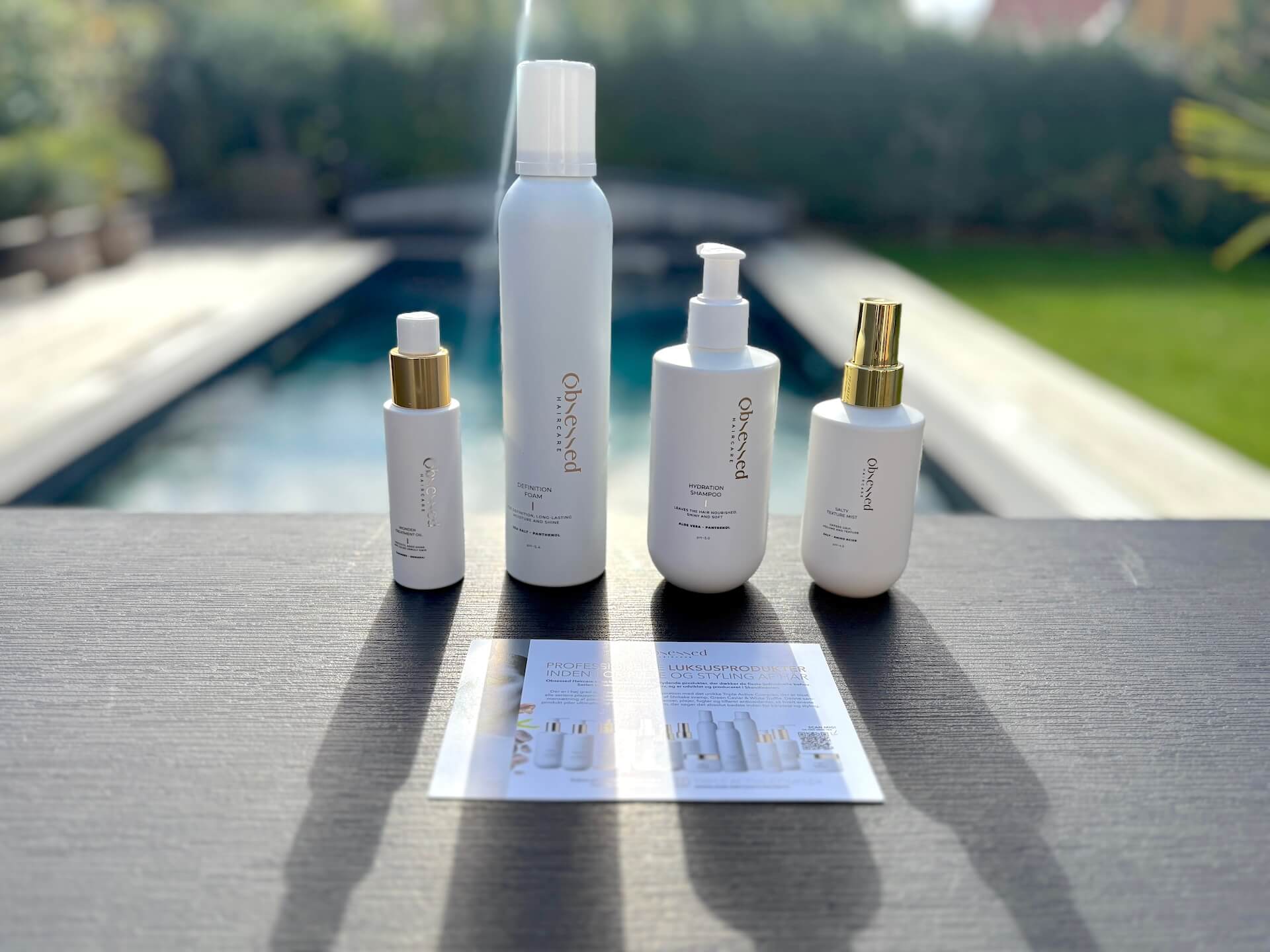 Obsessed Haircare Hydration Shampoo og andre produkter fra serien på bord