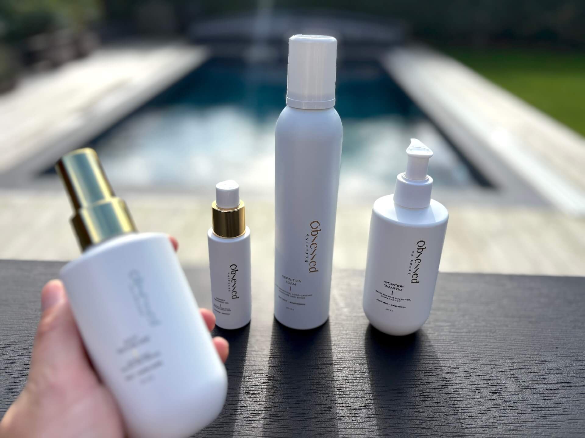 Obsessed Haircare Salty Texture Mist i hånd foran andre produkter fra serien