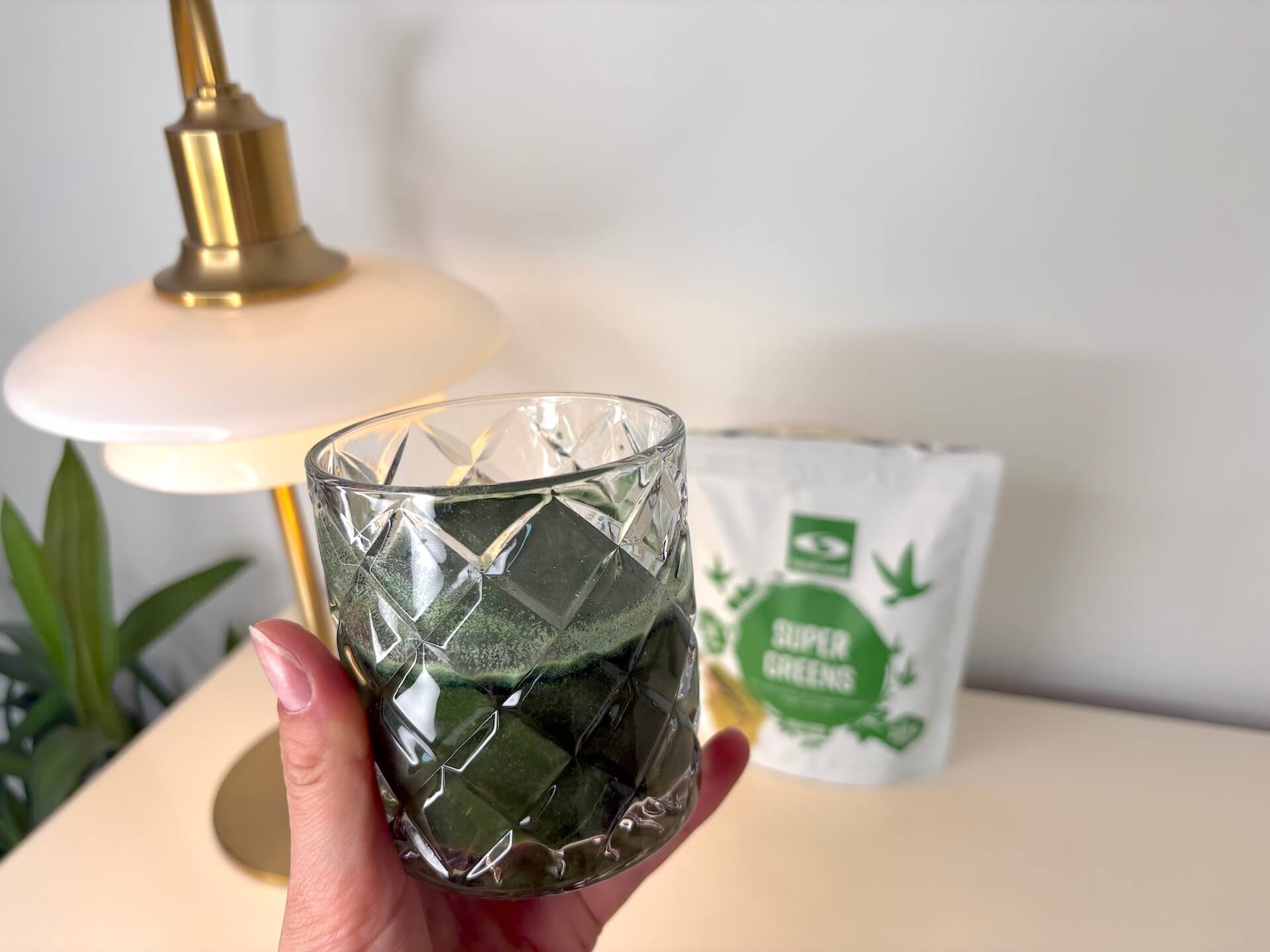 Opløst Healthwell Super Greens i vand i hånd