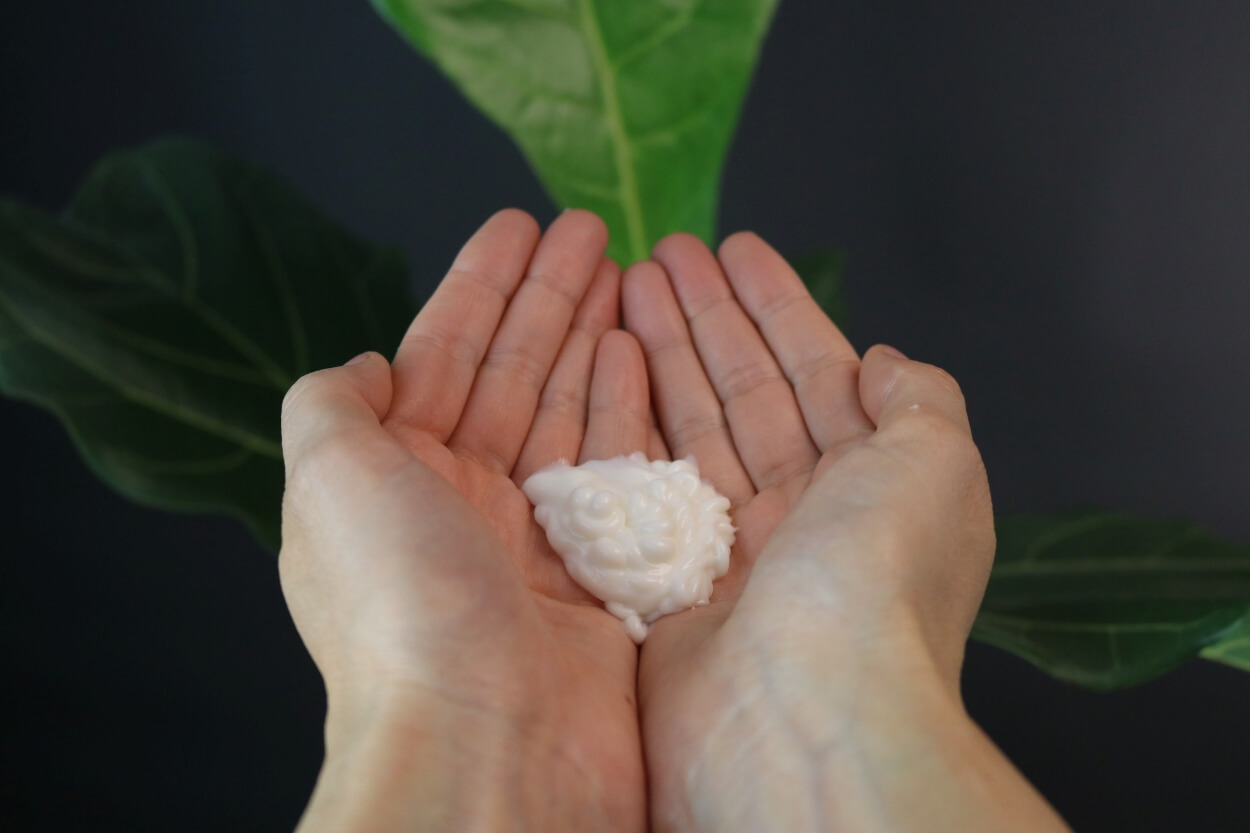 Person holder Hairlust krøllecreme i hænderne