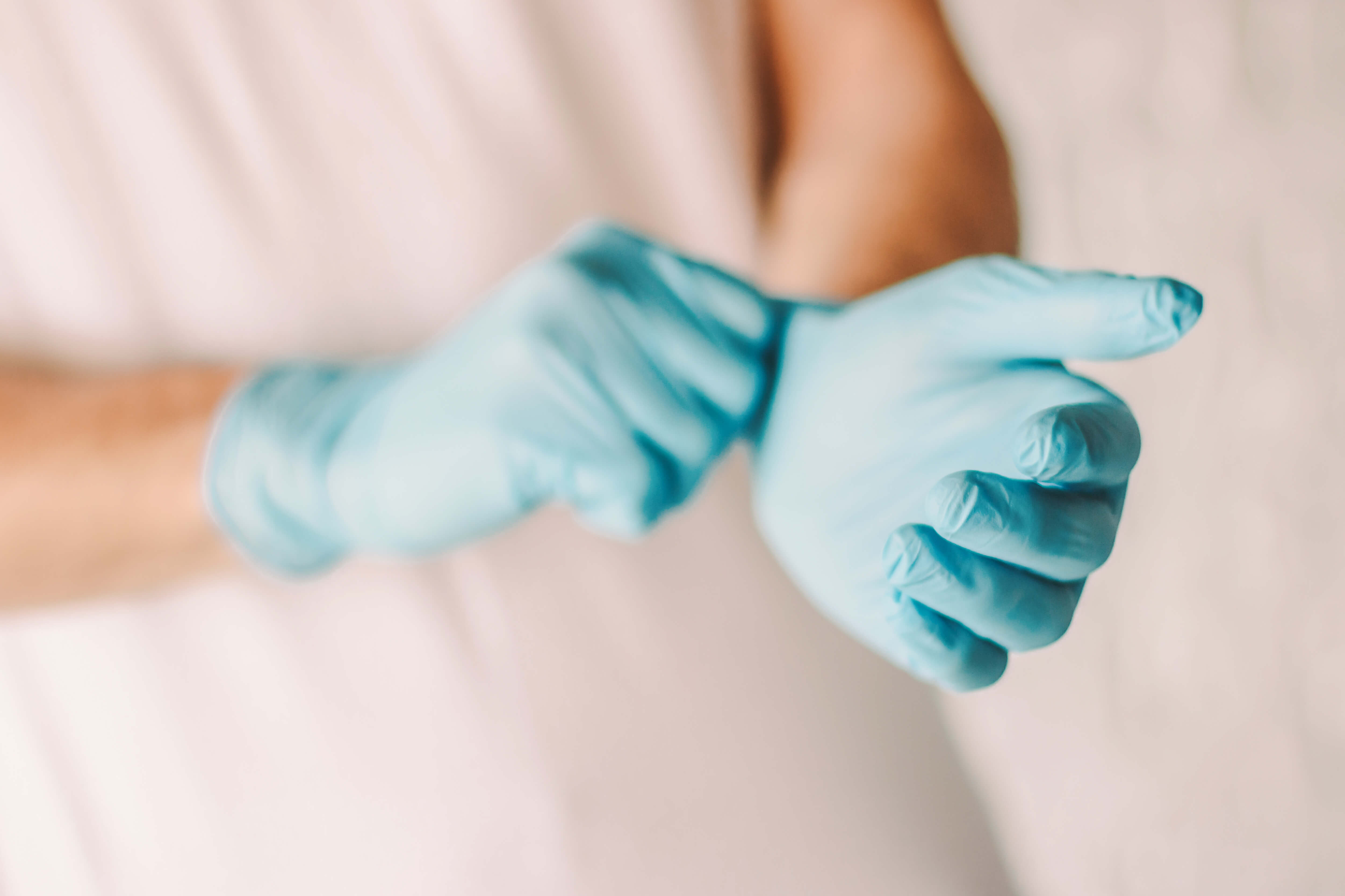 Person med latexhandsker på hænderne