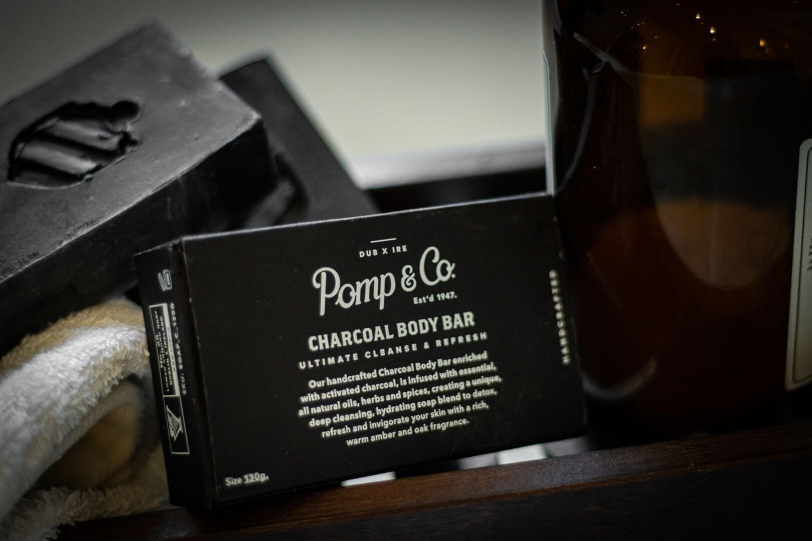 pomp & co charcoal sæbebar med en åben sæbebar i baggrunden