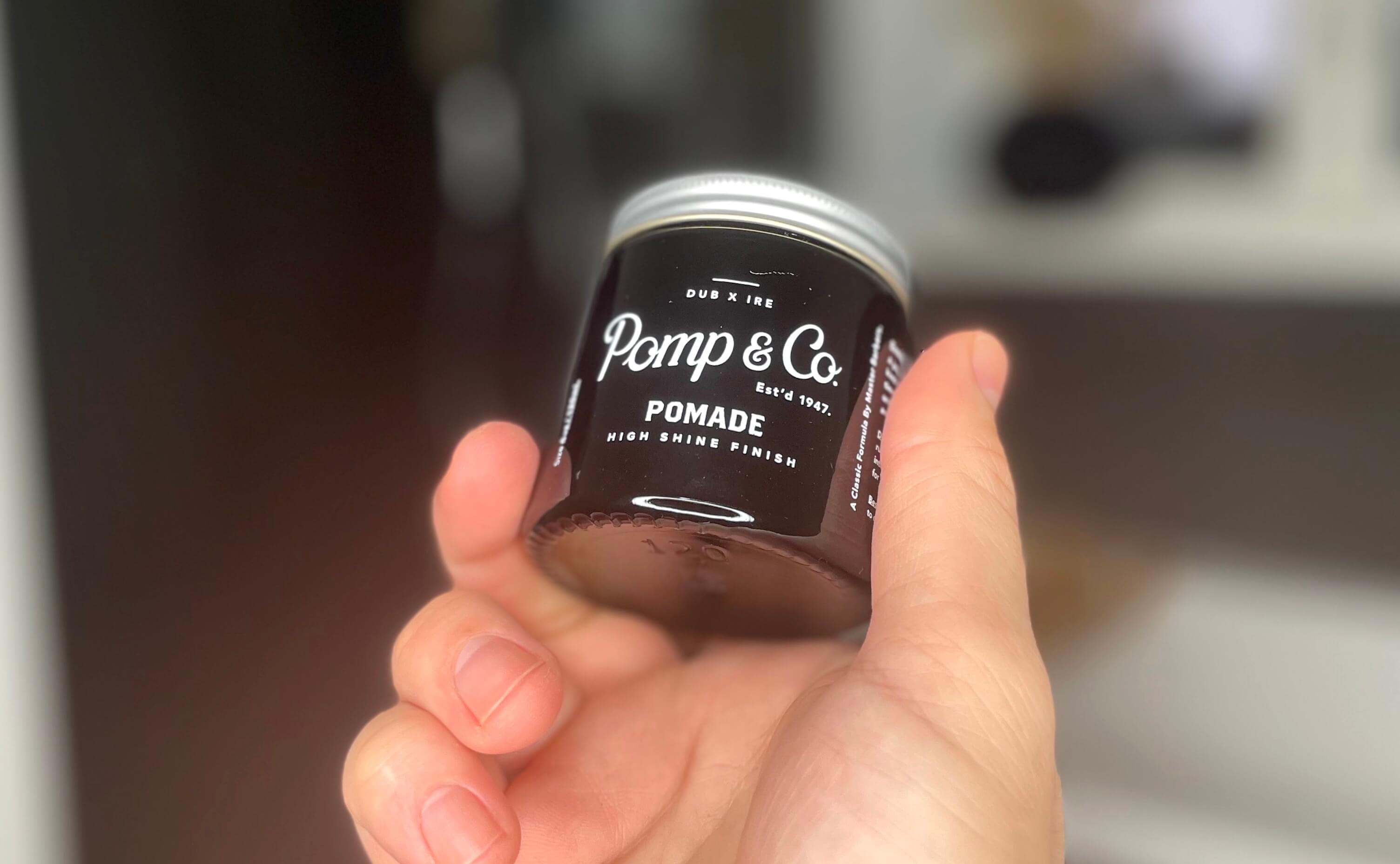 Pomp & Co pomade i hånden på en mand på et badeværelse