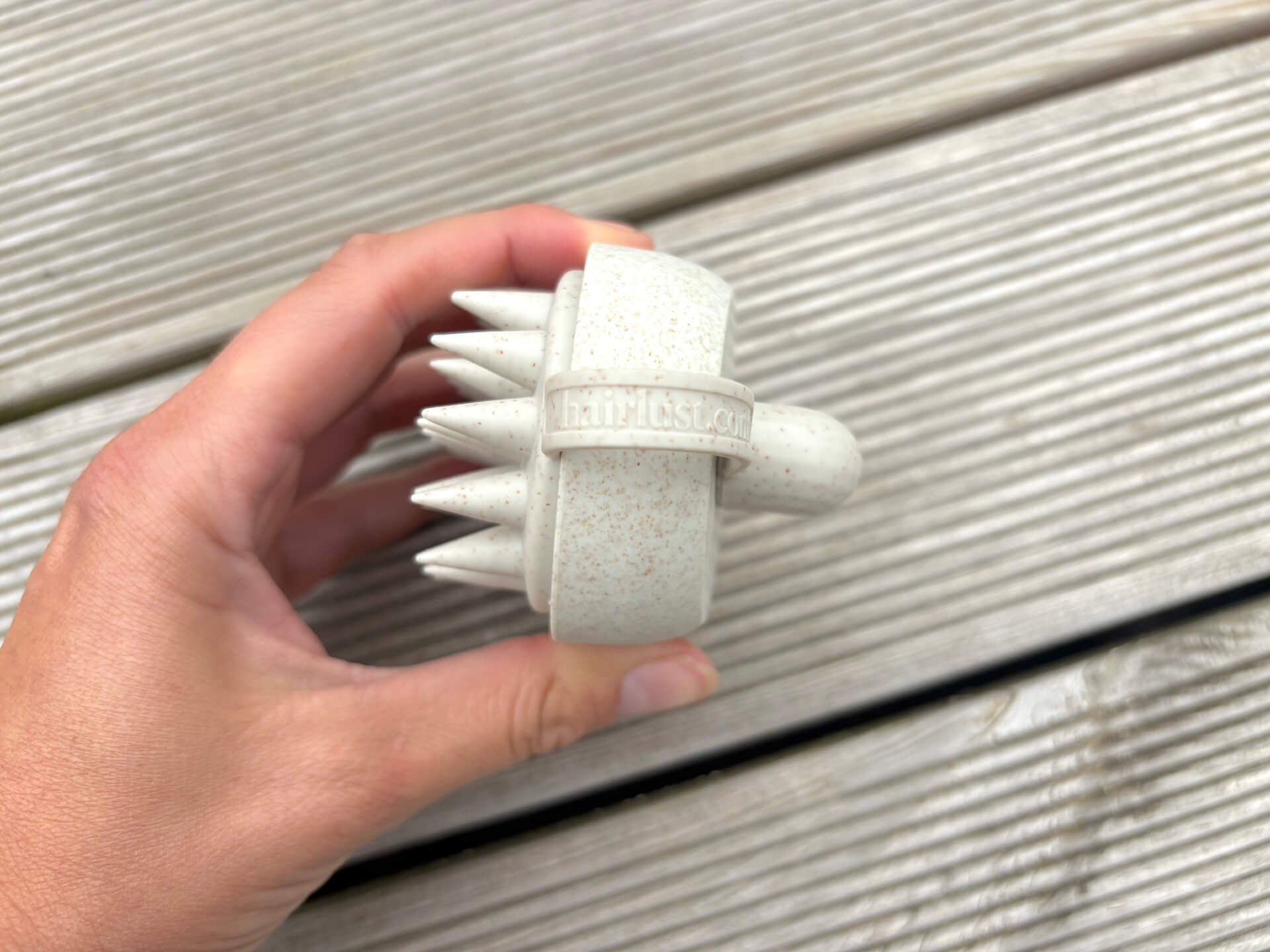 Side med logo på Hairlust In-Shower Shampoo Brush