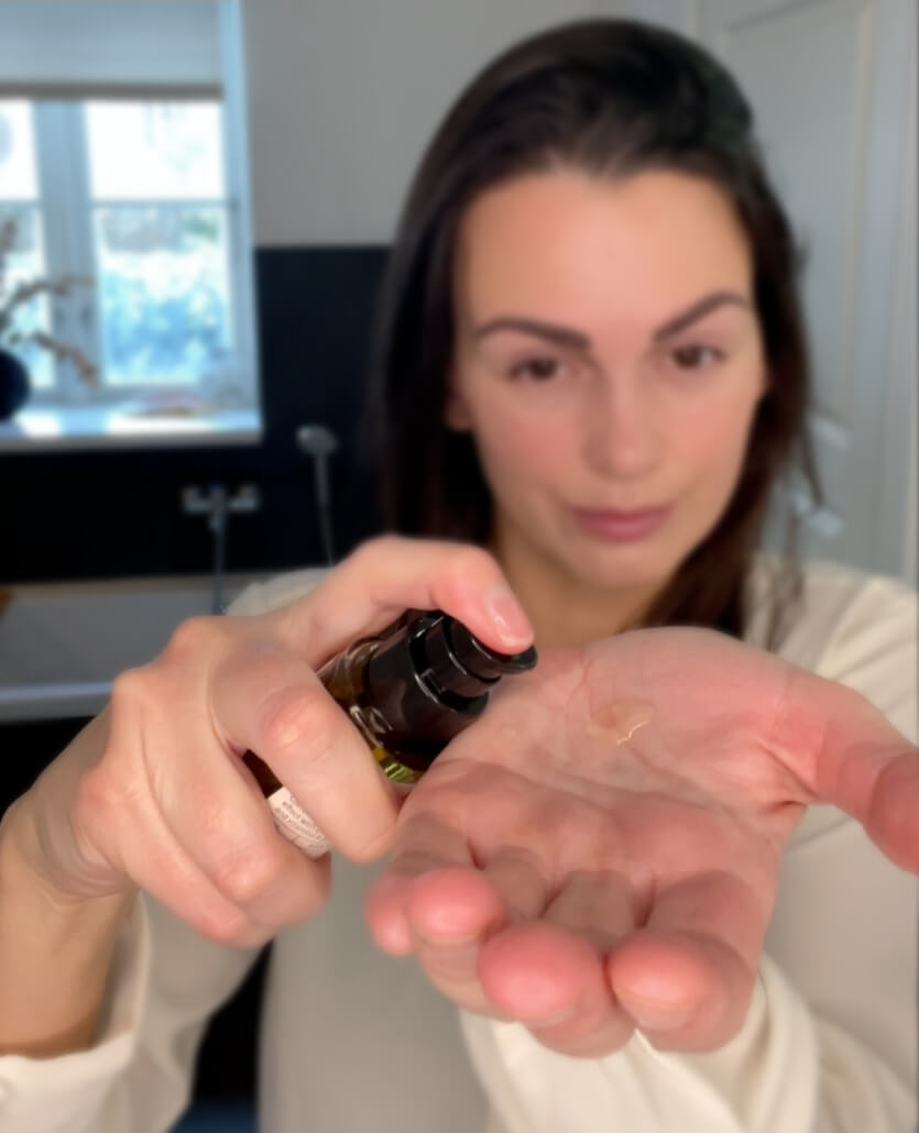 SKNS Face Serum Oil i hånden på kvinde