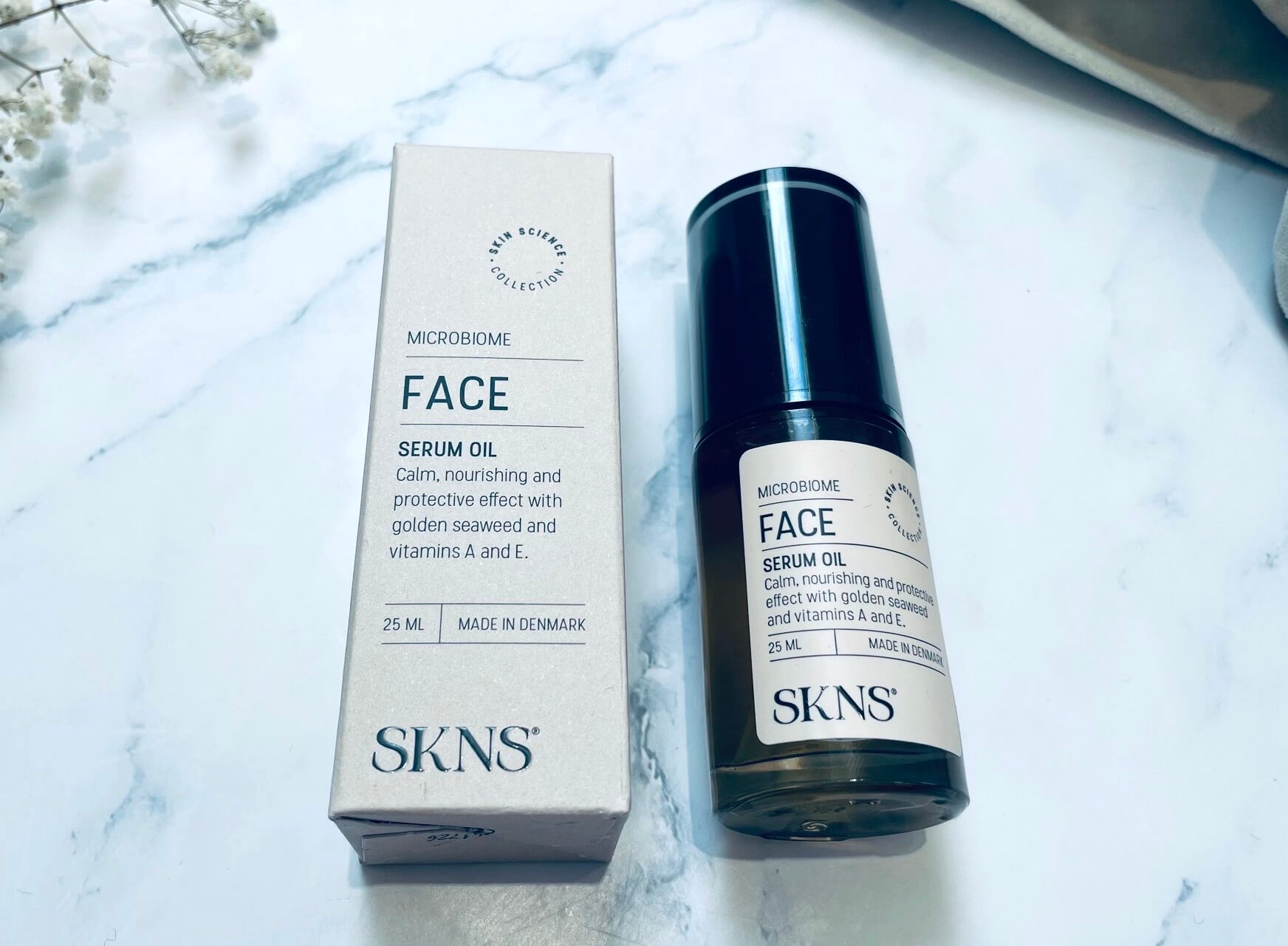 SKNS Face Serum Oil på bord med kasse