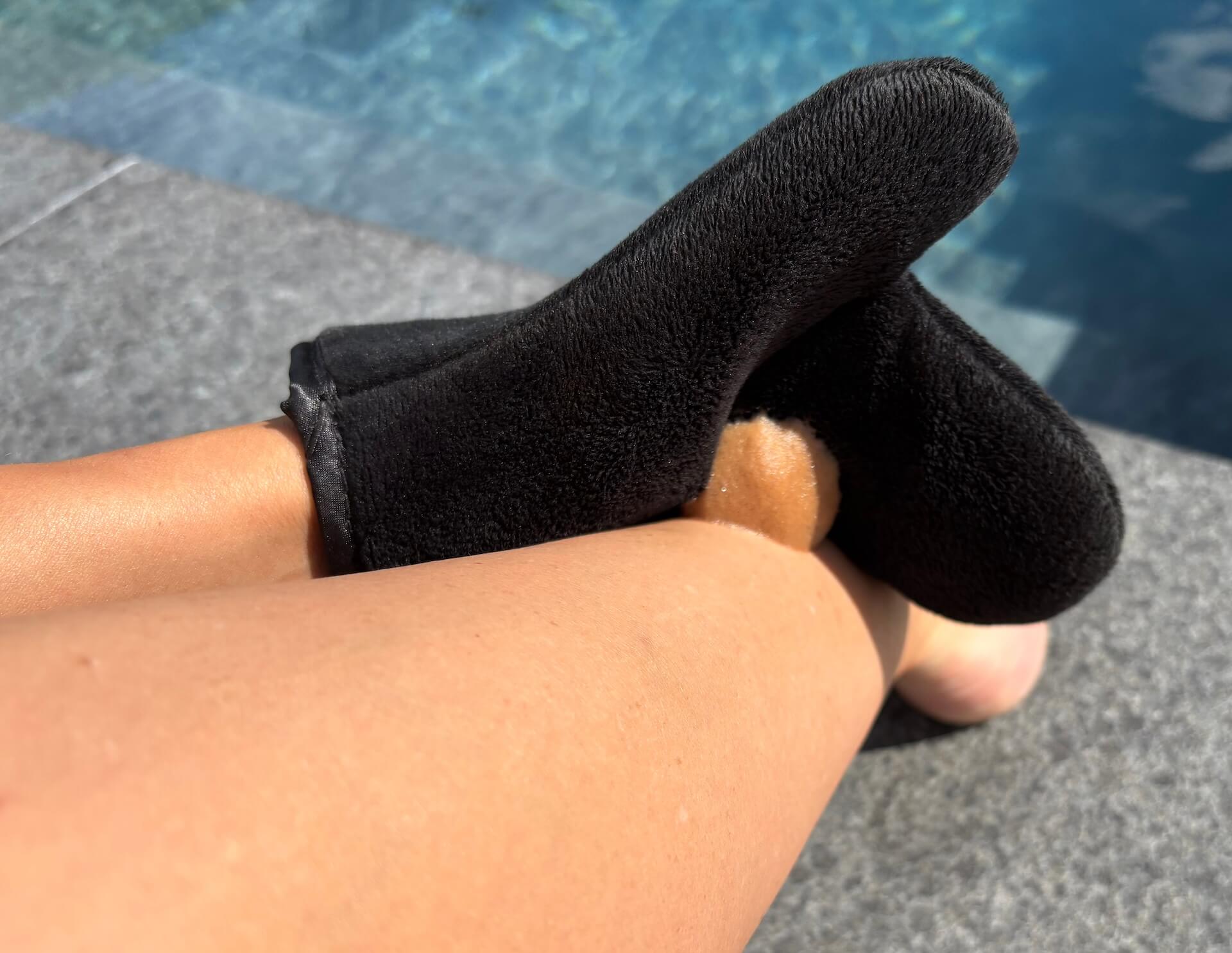 The Tan Co Instant Dark Selvbruner Mousse smøres ud på ben med handske