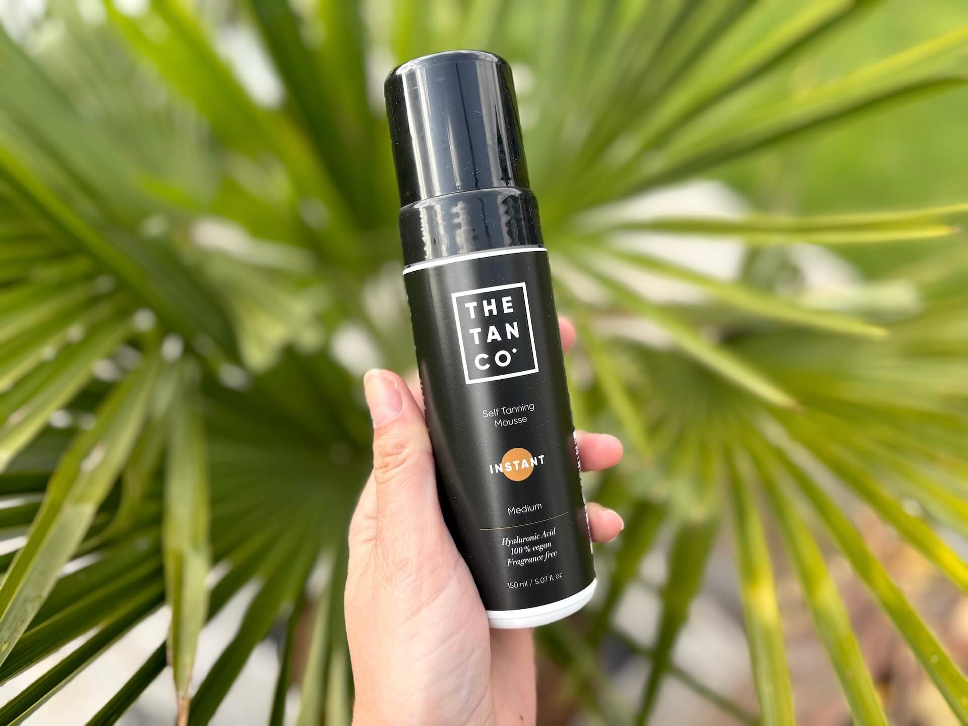 The Tan Co. Instant medium i hånd over palme