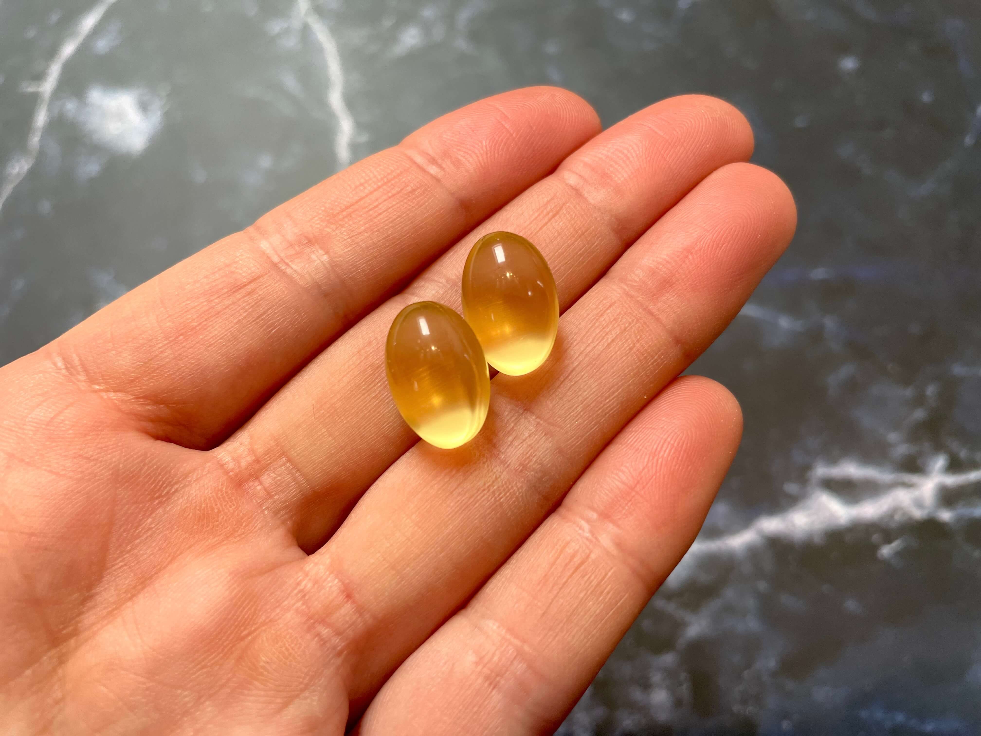 To Omega-3 Fiskeolie kapsler i hånd