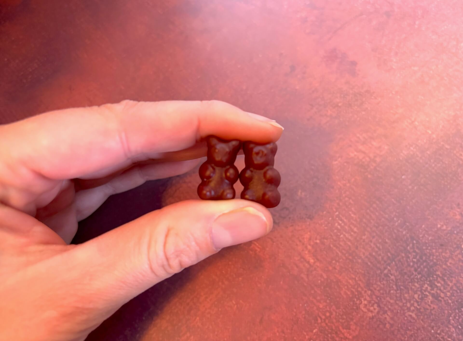 To WeightWorld Iron & Vitamin C Gummies mellem fingre