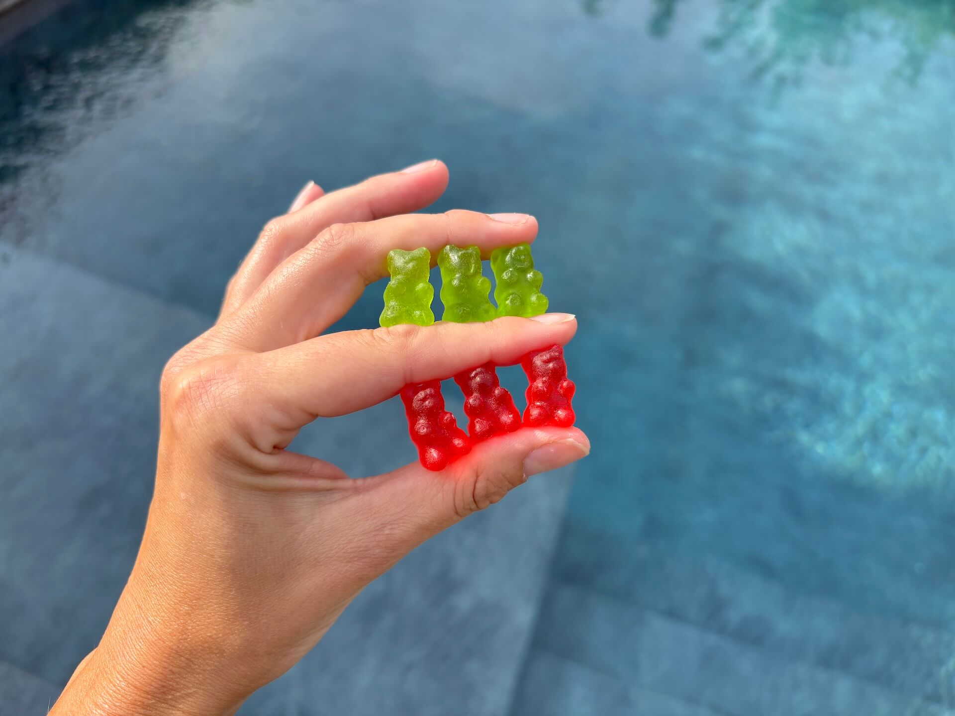 Tre grønne og tre røde Gummi Gainz Creatine Gummies i hånd