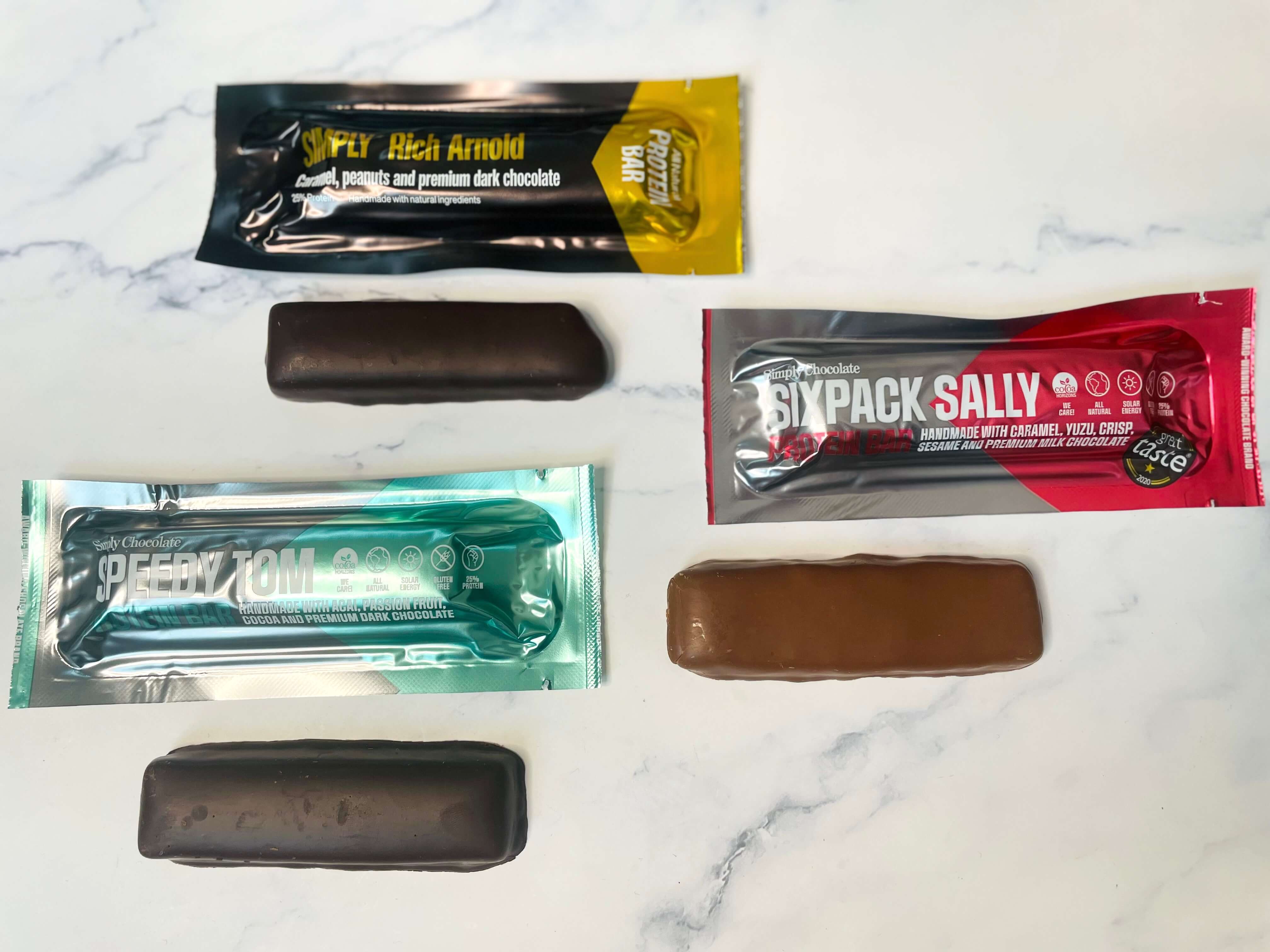Tre slags proteinbarer fra Simply Chocolate på et bord