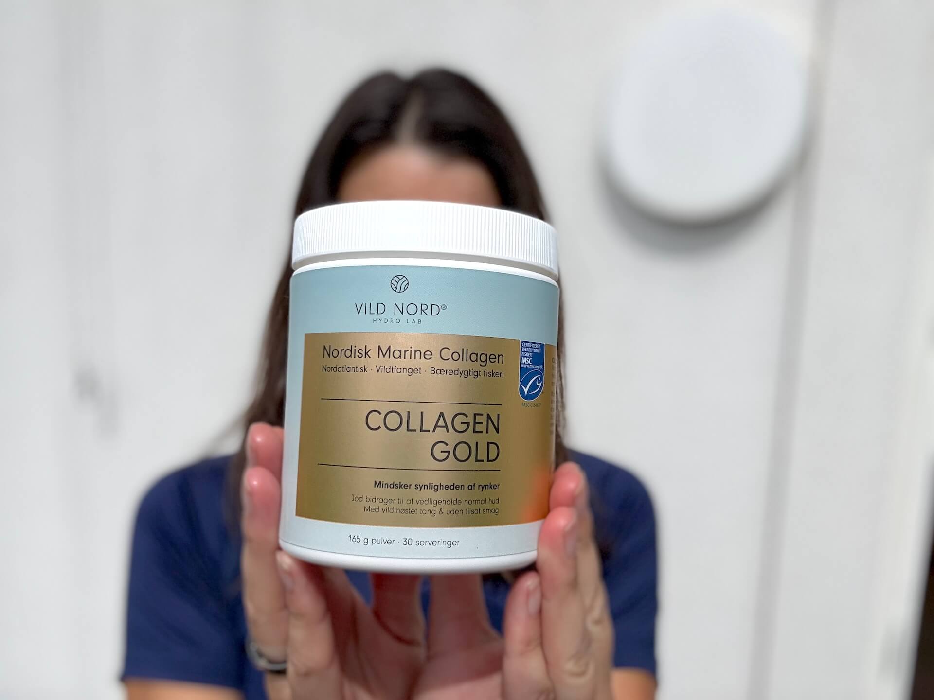 Vild Nord Collagen Gold foran kvinde der holder det