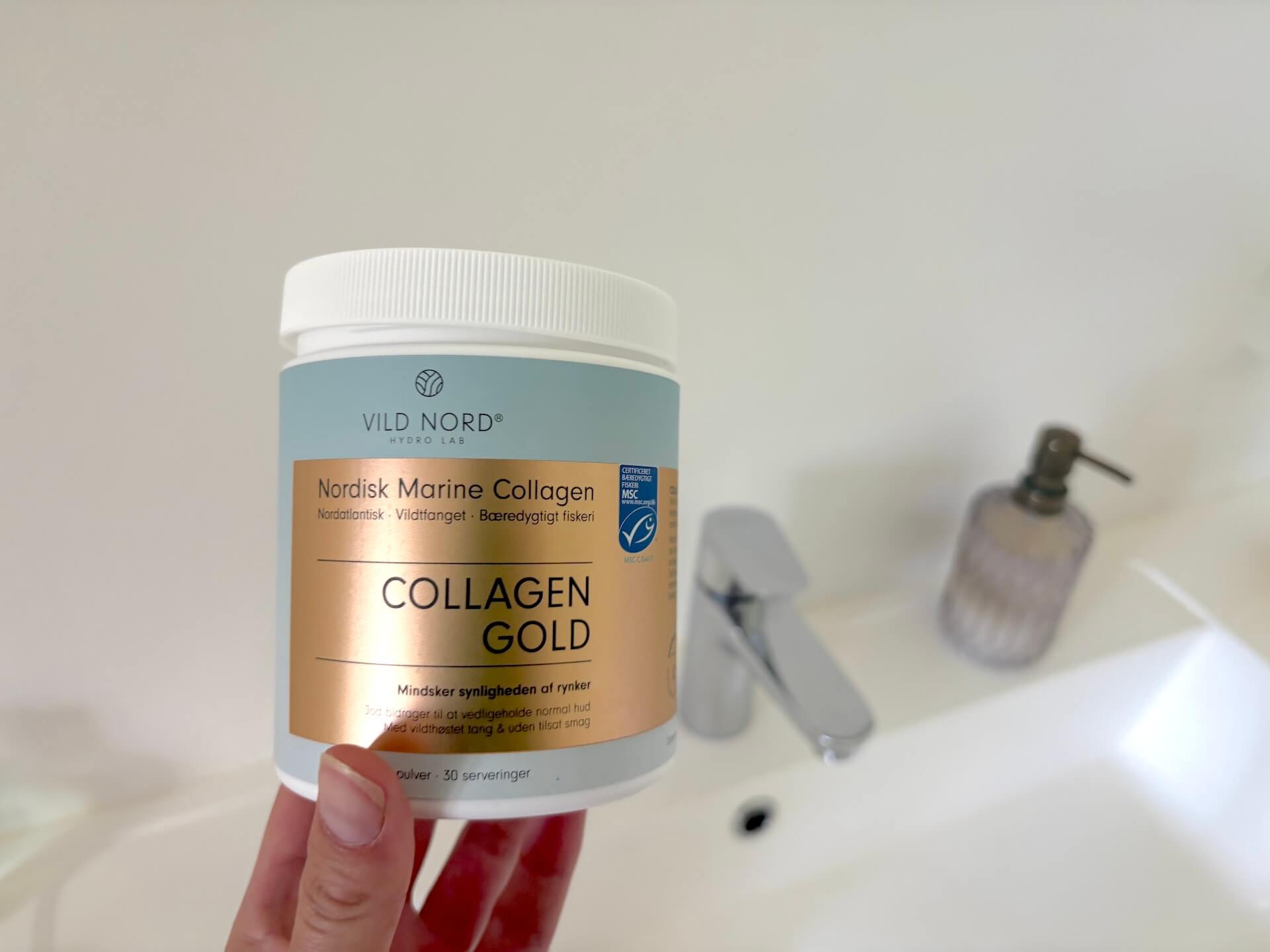 Vild Nord Collagen Gold i hånd på badeværelse