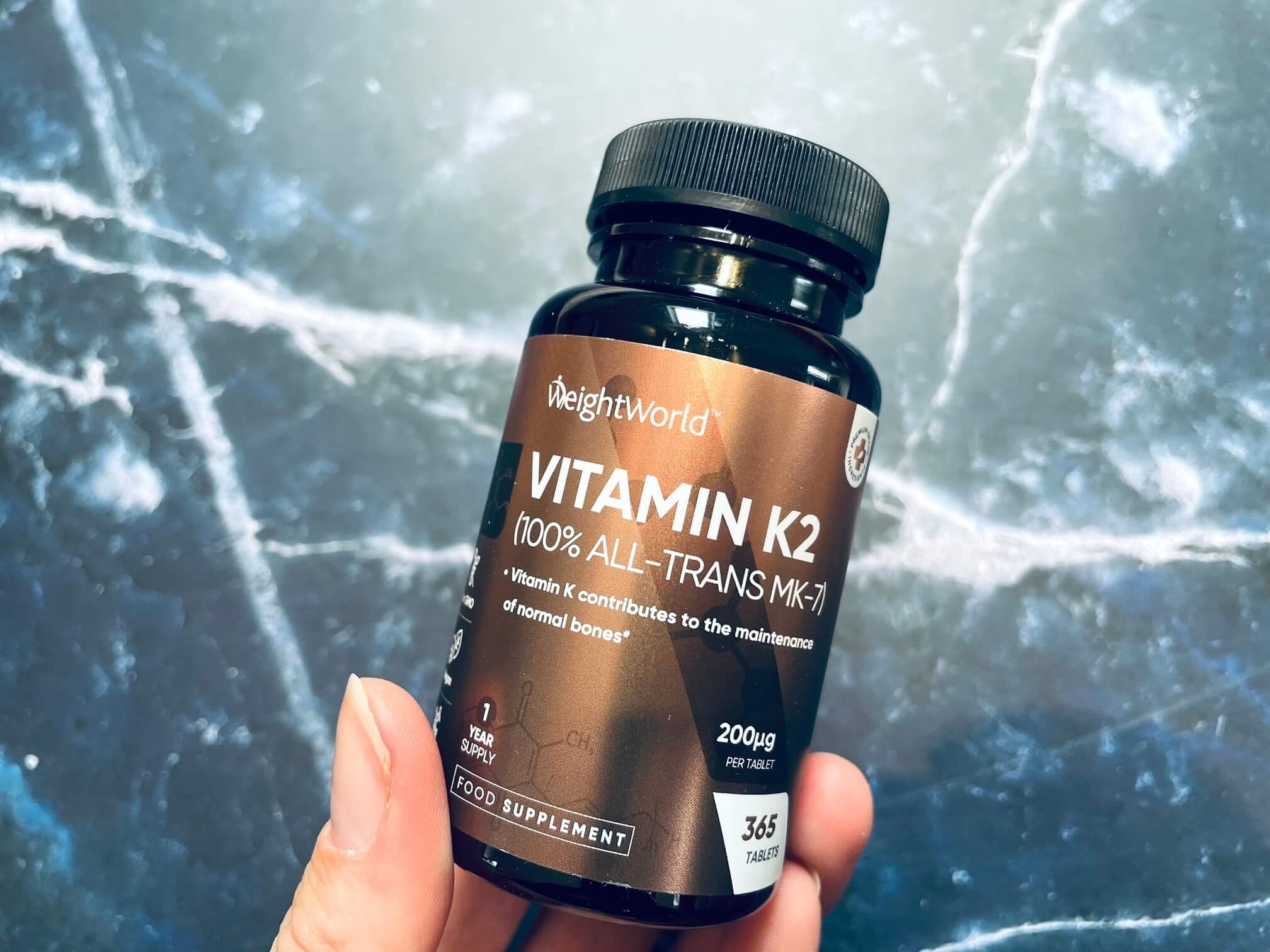 Weightworld Vitamin K2 K-vitamin bøtte i en hånd