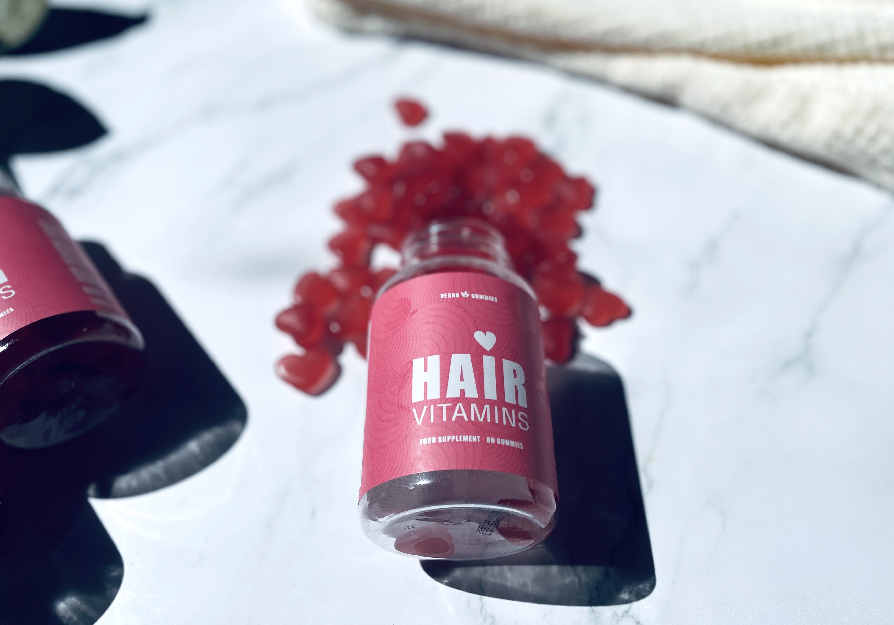Yuaia Haircare hårvitaminer ligger åben på bord med hårvitaminer over