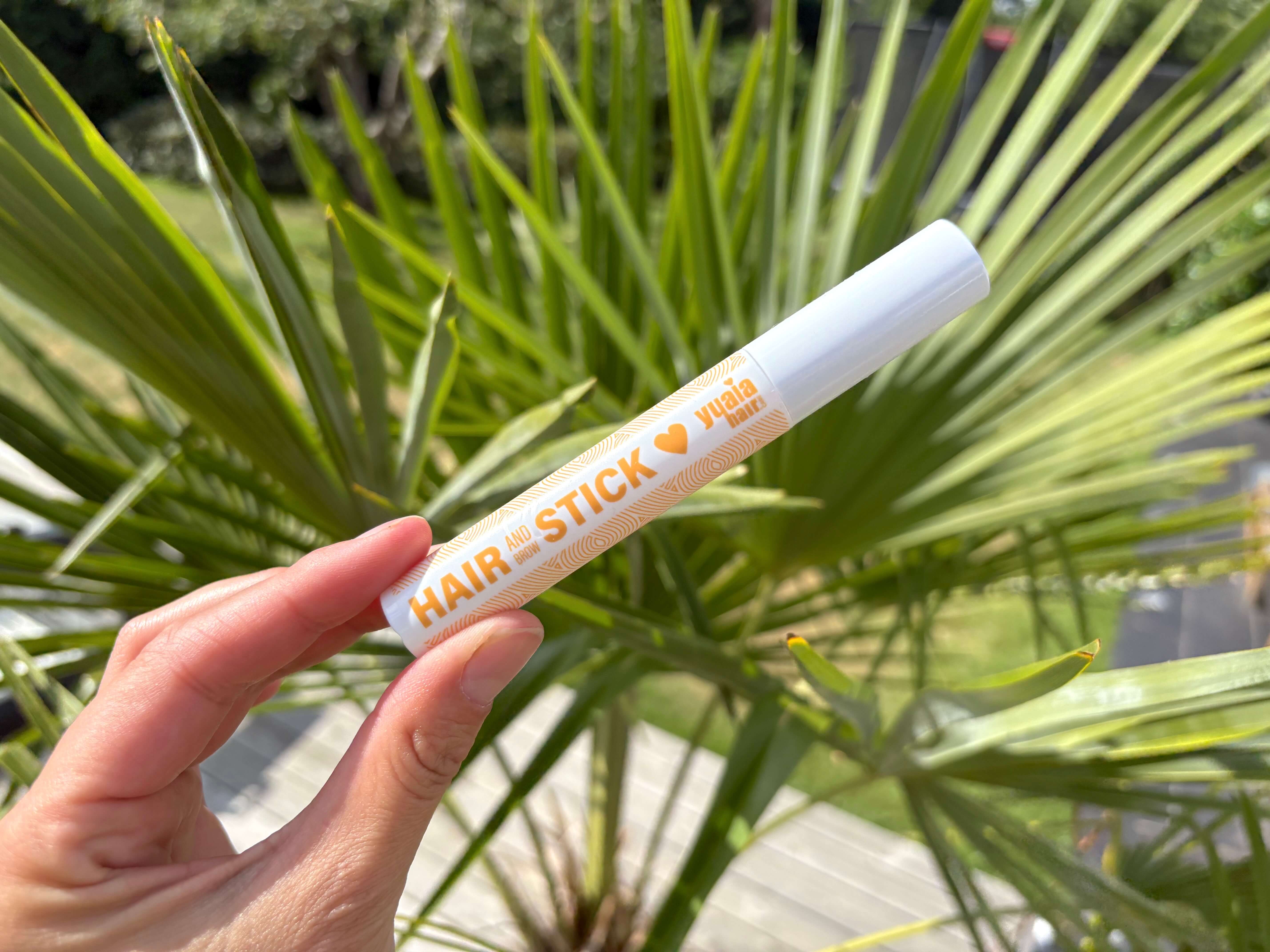 Yuaia Haircare Hair and Brow Stick i hånd over palme
