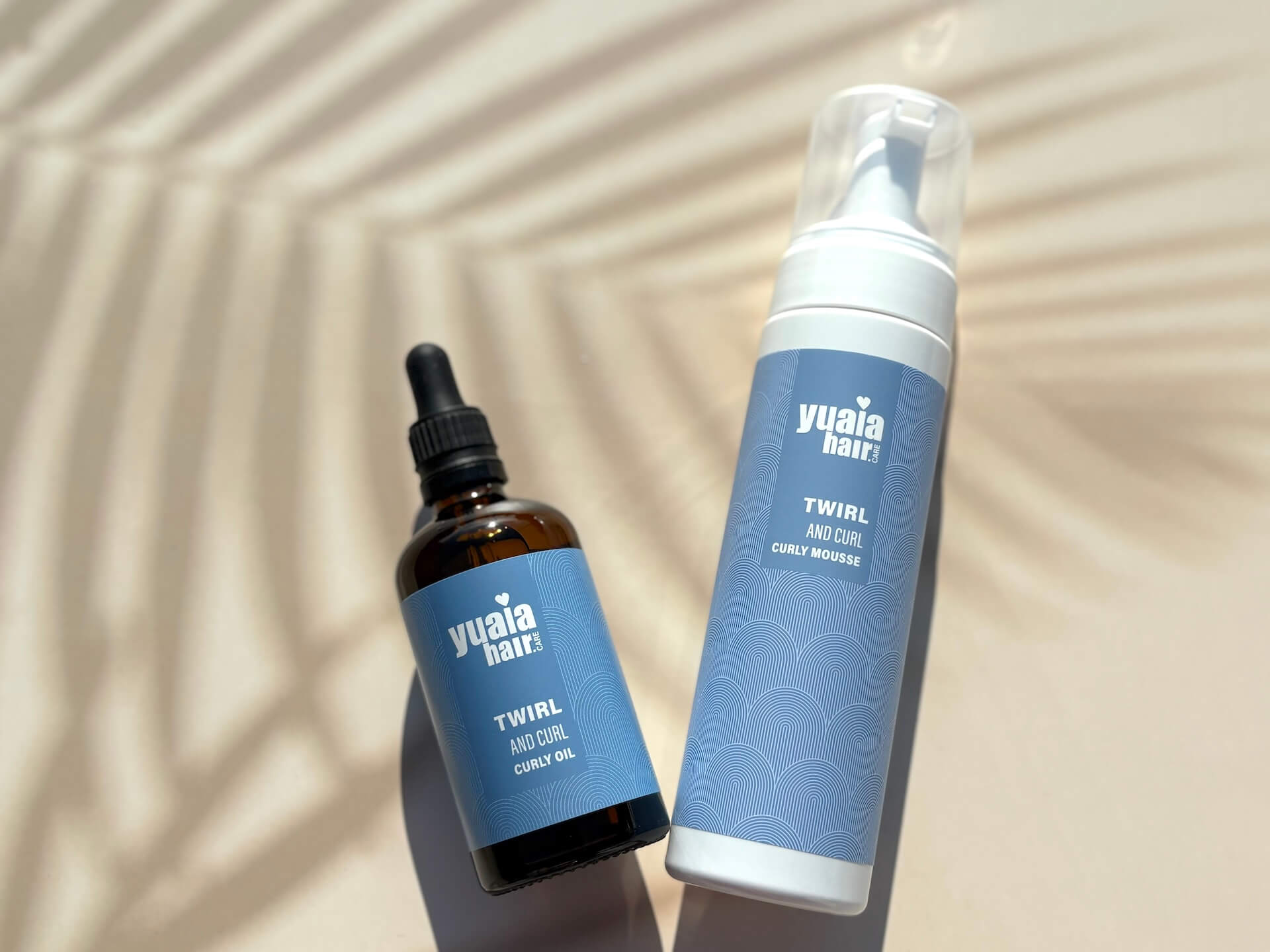 Yuaia Haircare Twirl and Curl Curly Mousse og oil på bord