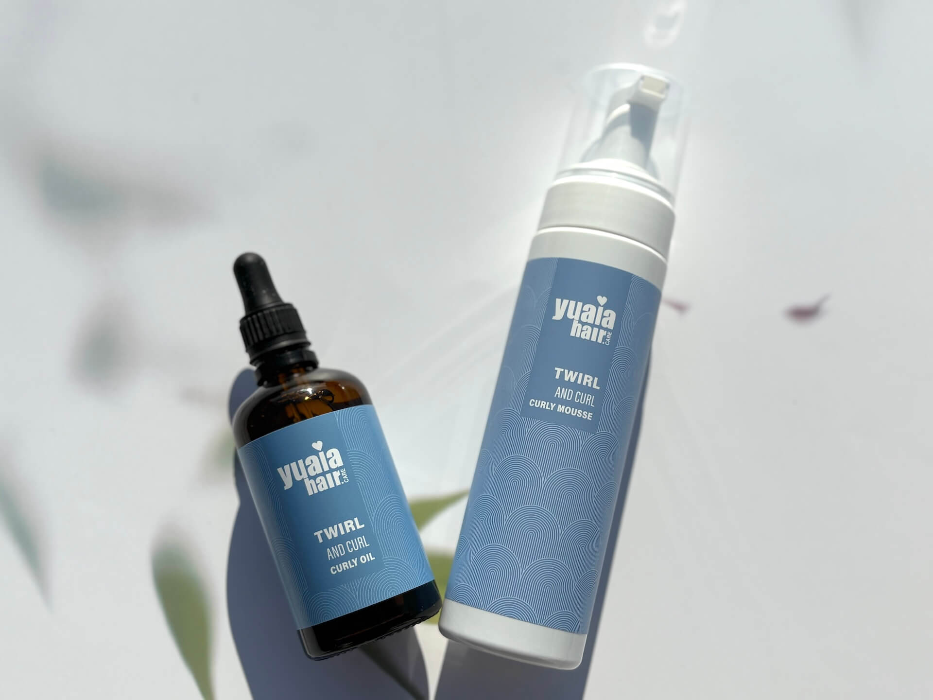 Yuaia Haircare Twirl and Curl Curly Oil og mousse på bord